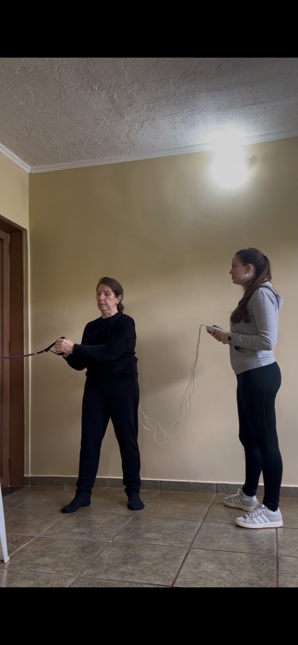 Mariana Domeneghetti acompanhando exercício terapêutico com faixa elástica
